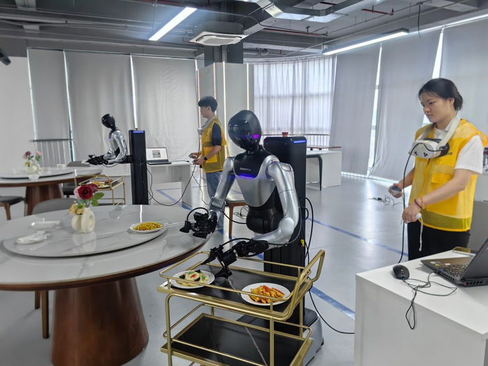 8月6日，李斯佳（右）和同事正在对机器人进行训练。新华社记者张紫赟 摄
